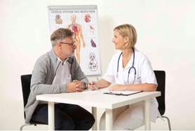 Patient und Ärztin am Tisch sitzend im Gespräch