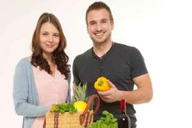 Junges Ehepaar mit Tasche voll Gemüsse und Obst