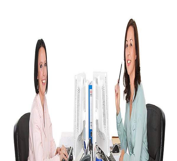 Frauen an Computern sitzen sich gegenüber